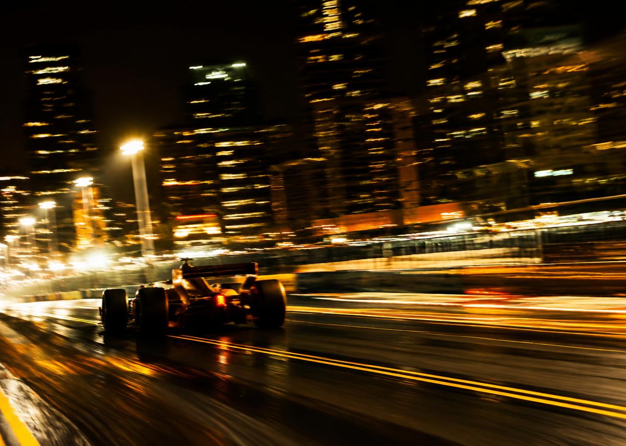 Night street-circuit racing captured with long-exposure light trails